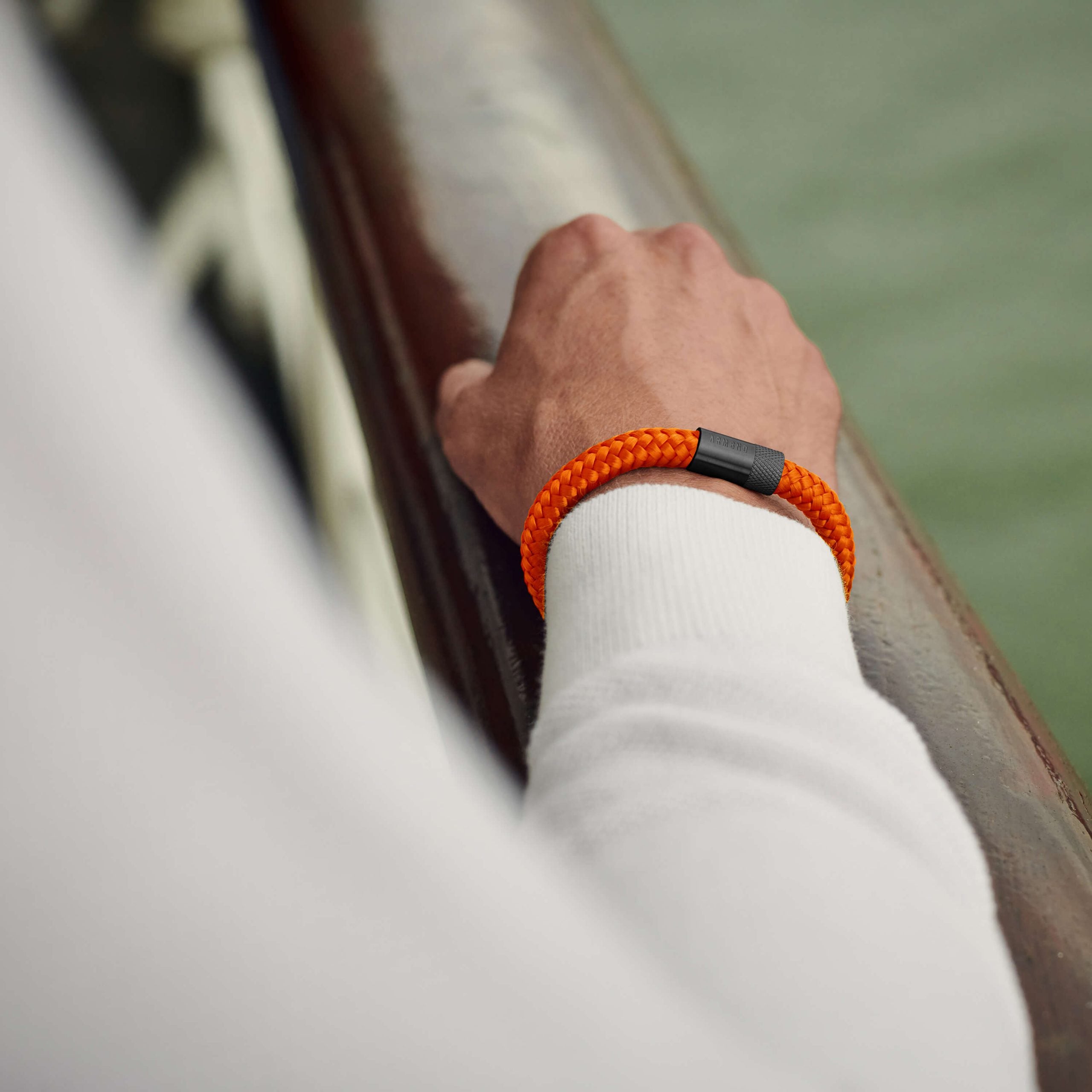 Detailfoto van de oranje ARMBND The Orange Original armband, close-up op de gevlochten streng